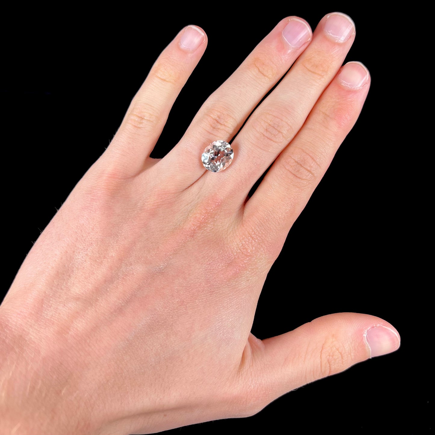 A loose, faceted oval cut pink morganite gemstone.