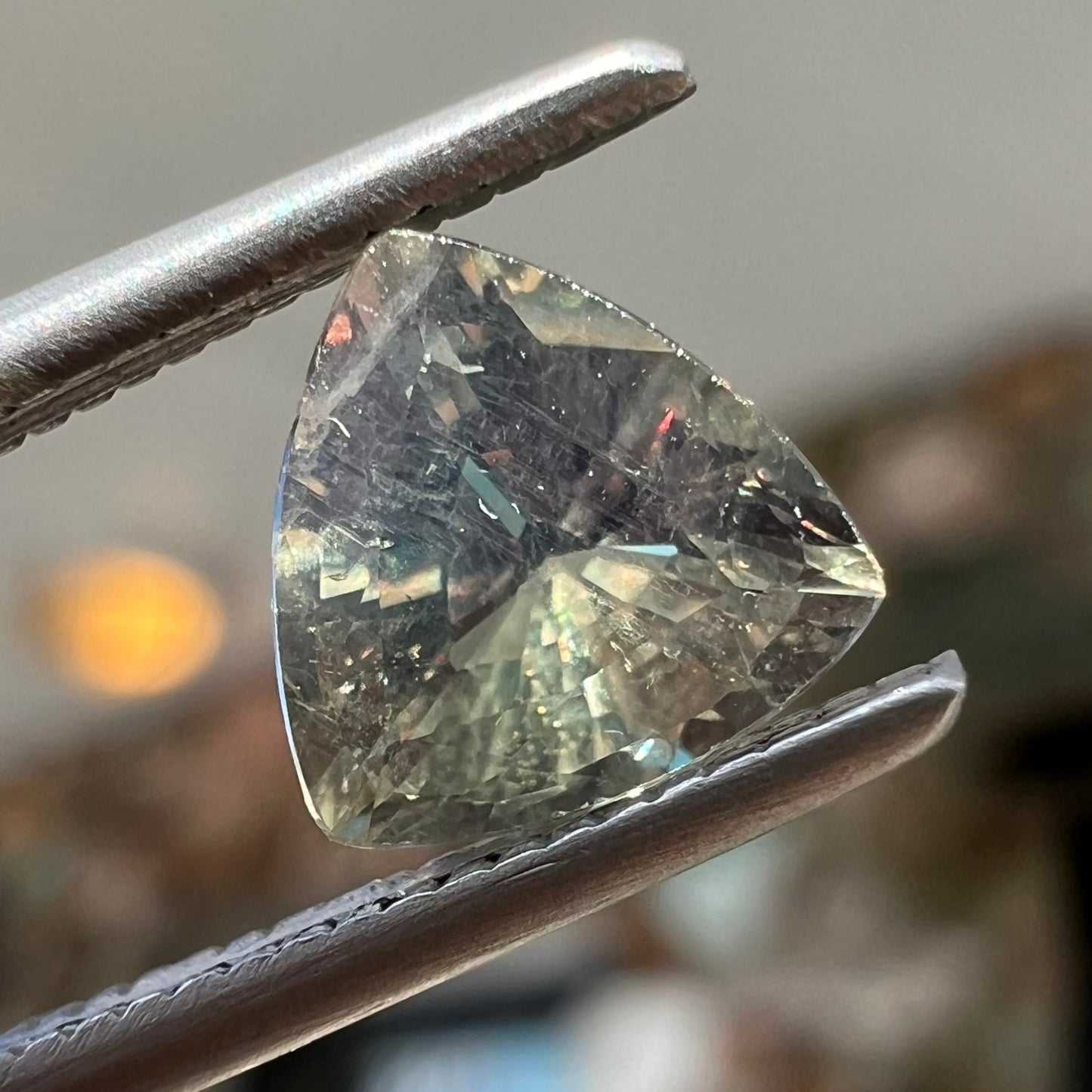 A natural, 1.10 carat, trillion cut alexandrite gemstone. The stone changes colors from dark olive green to faint purplish green.