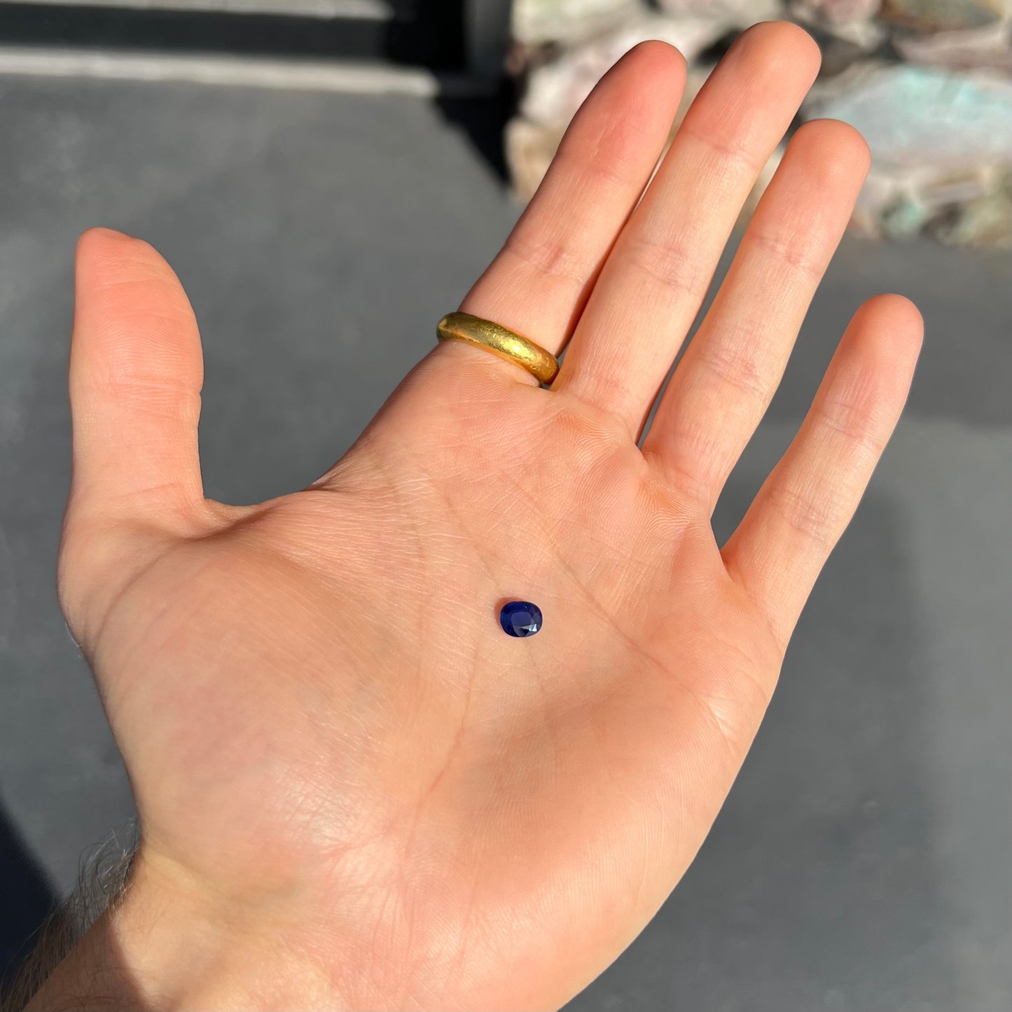 A loose, faceted oval cut dark blue natural sapphire stone.