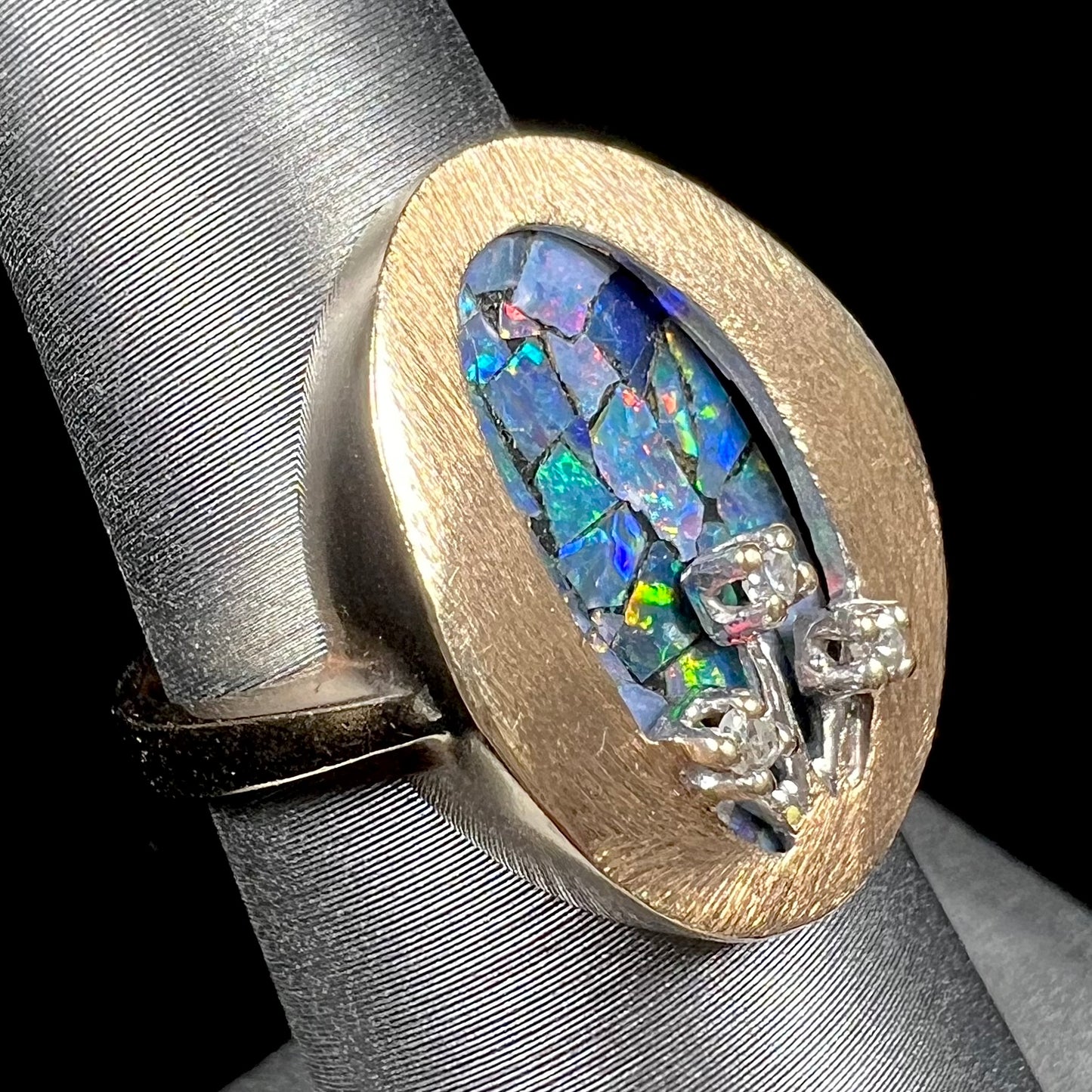 A vintage mosaic opal ring set with diamond accents in 10 karat yellow and white gold.