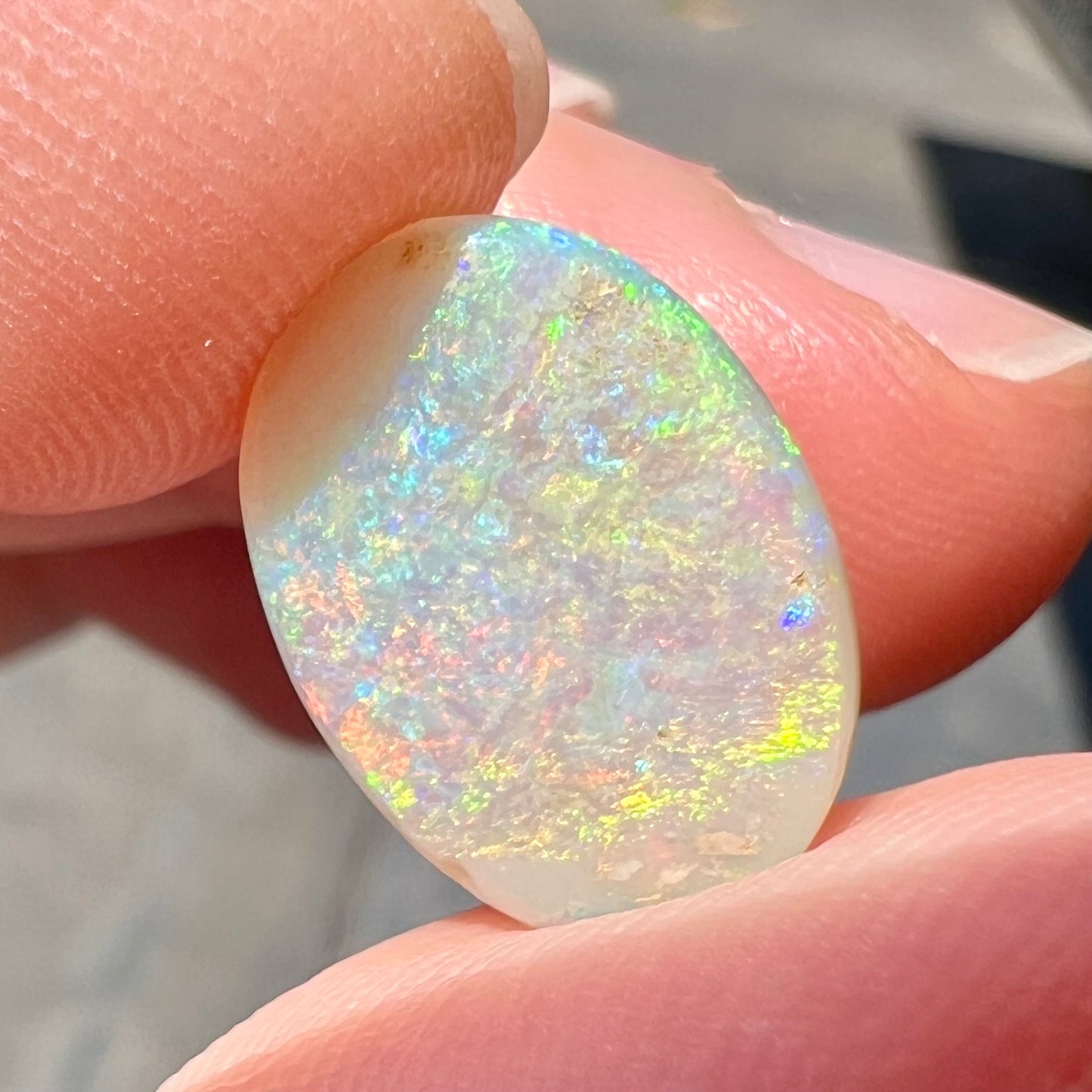 A double-sided opal stone from Coober Pedy, Australia. The opal plays green, blue, and orange colors from the front and the back.