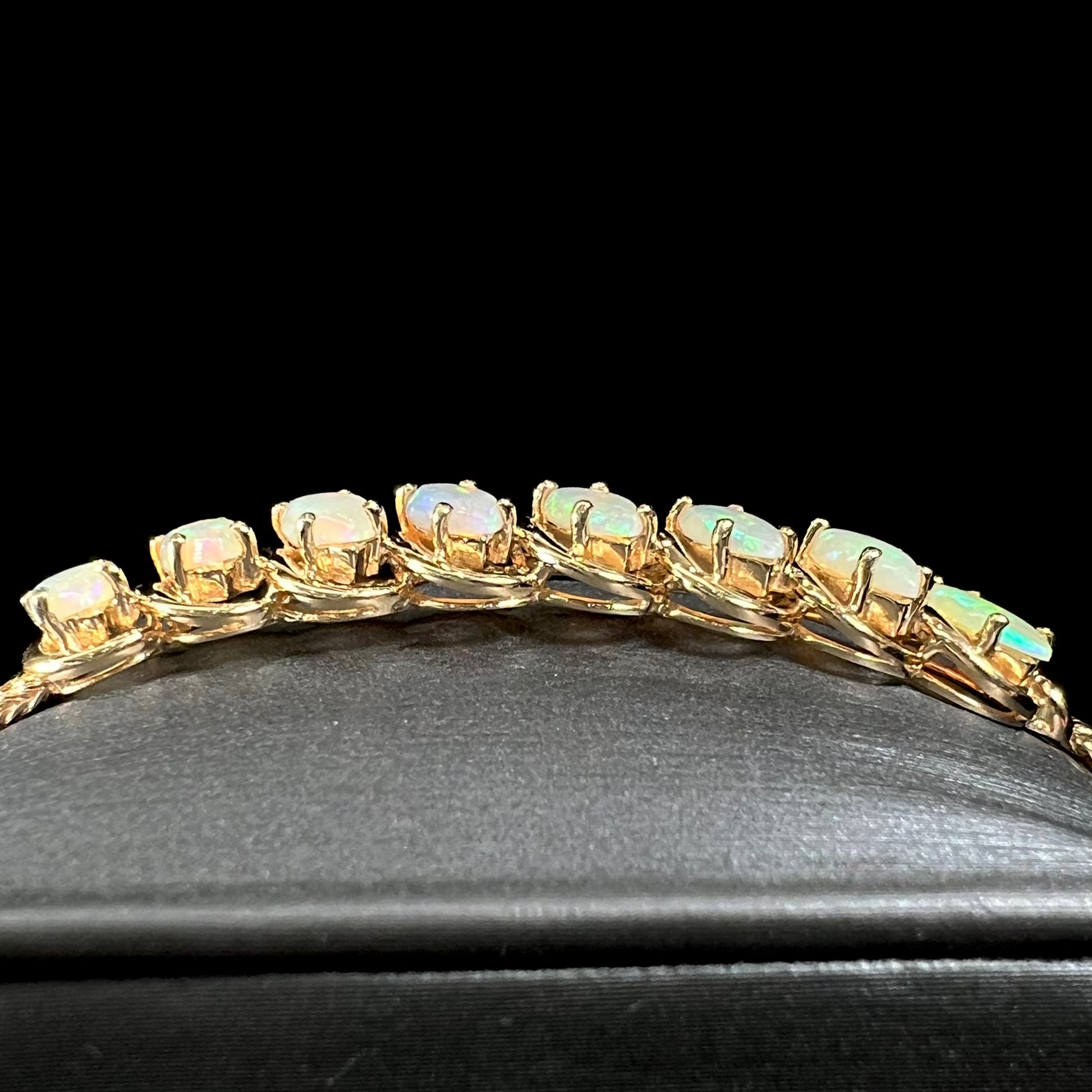 A ladies' yellow gold bracelet prong set with eight natural, marquise cabochon cut opals.