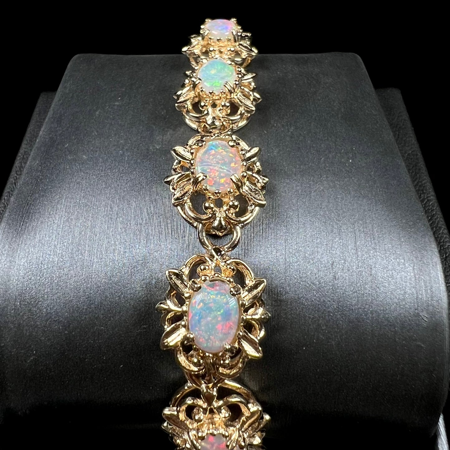 A ladies' yellow gold bracelet set with natural, oval cabochon cut white crystal opals.