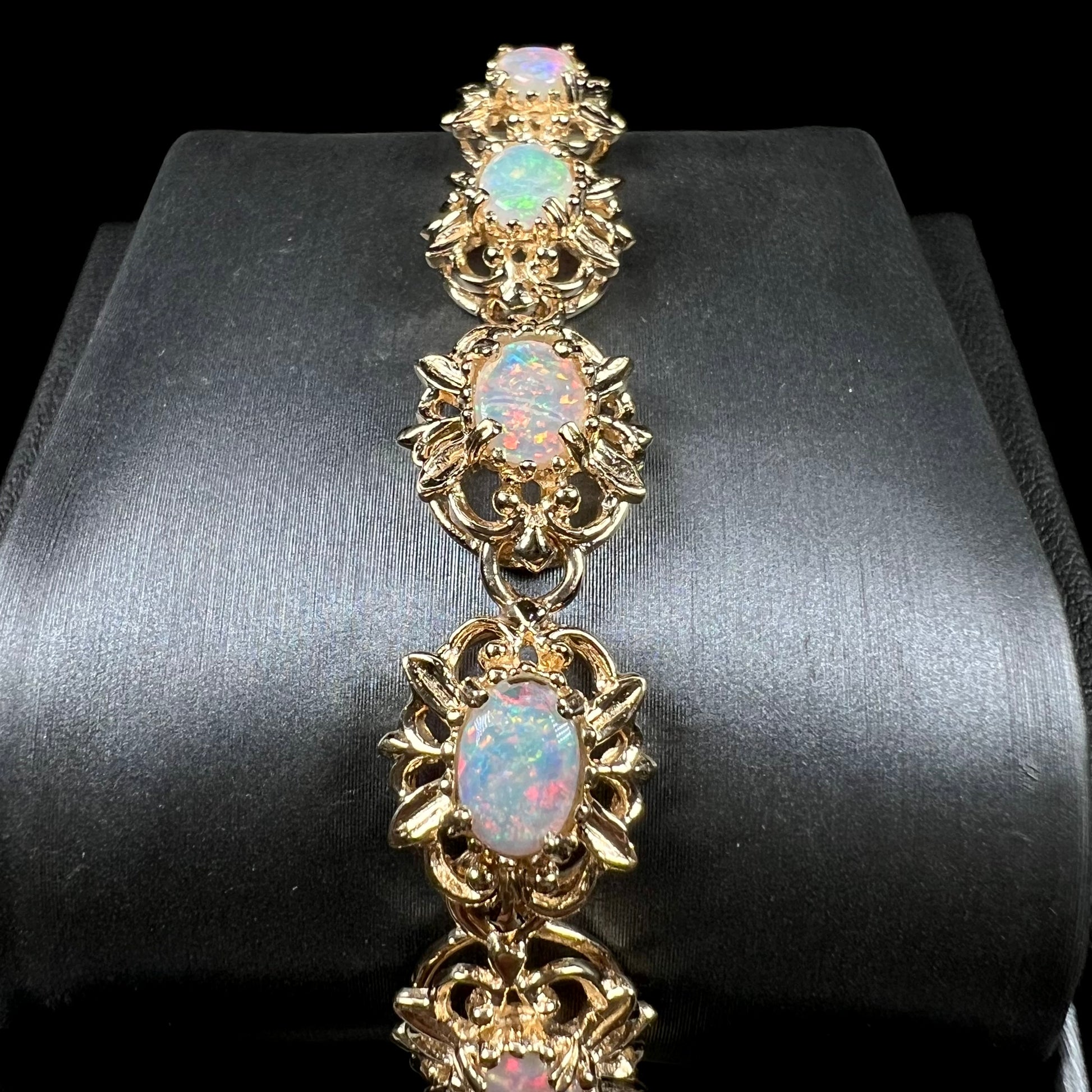 A ladies' yellow gold bracelet set with natural, oval cabochon cut white crystal opals.