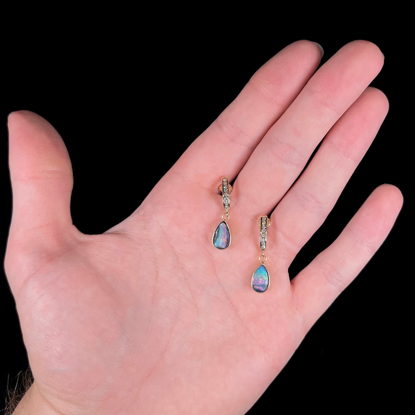 A pair of yellow gold dangle earrings set with natural pear shaped boulder opals and diamonds.
