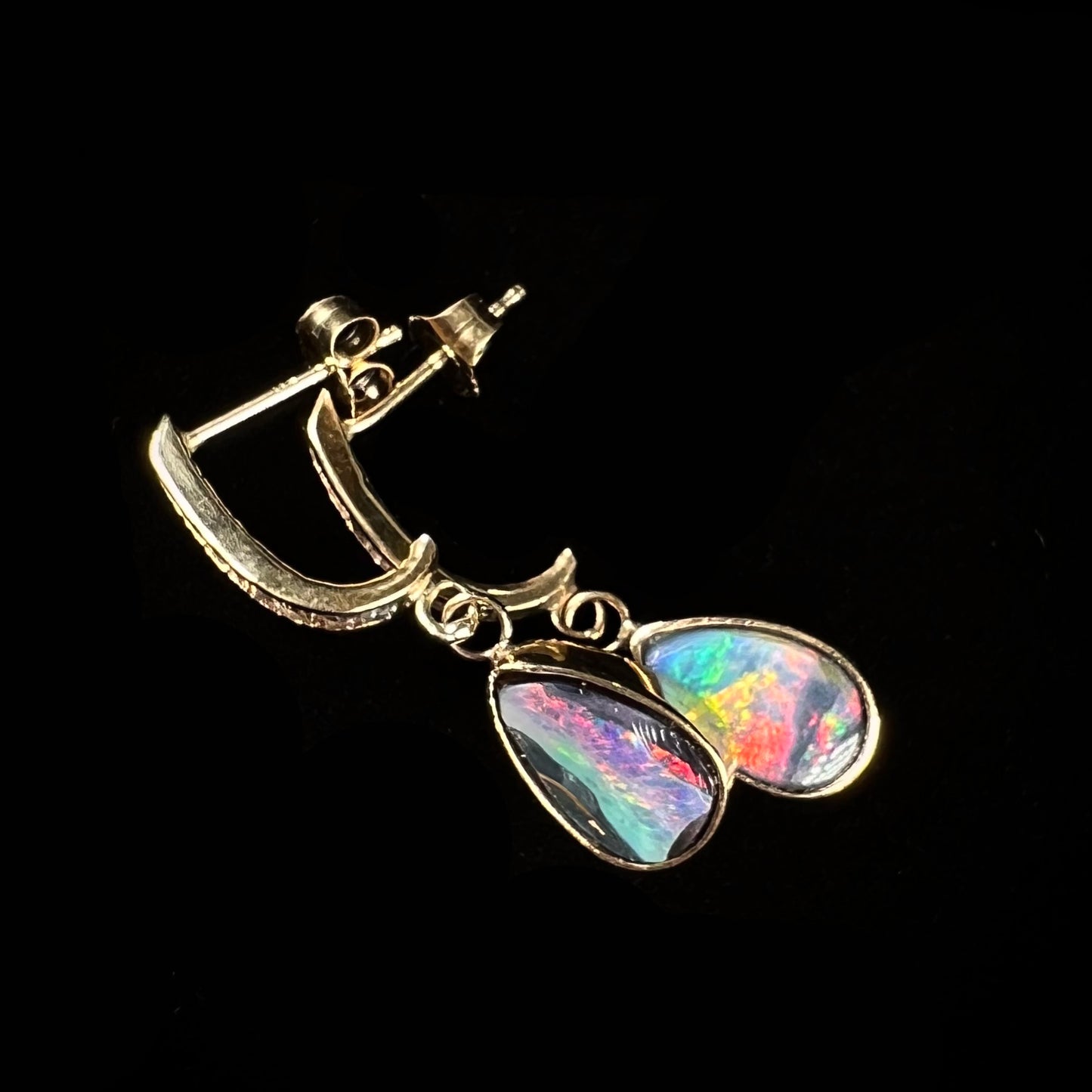 A pair of yellow gold dangle earrings set with natural pear shaped boulder opals and diamonds.