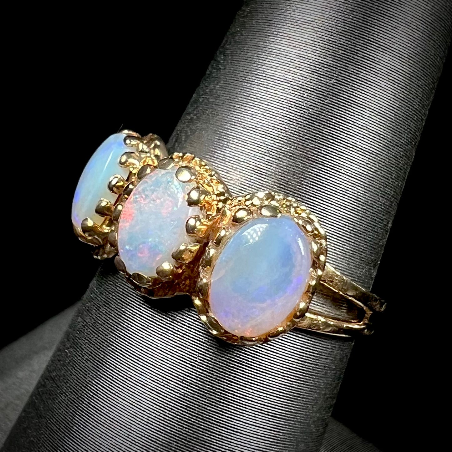 A vintage ladies' three stone gold ring set with natural white crystal opals.