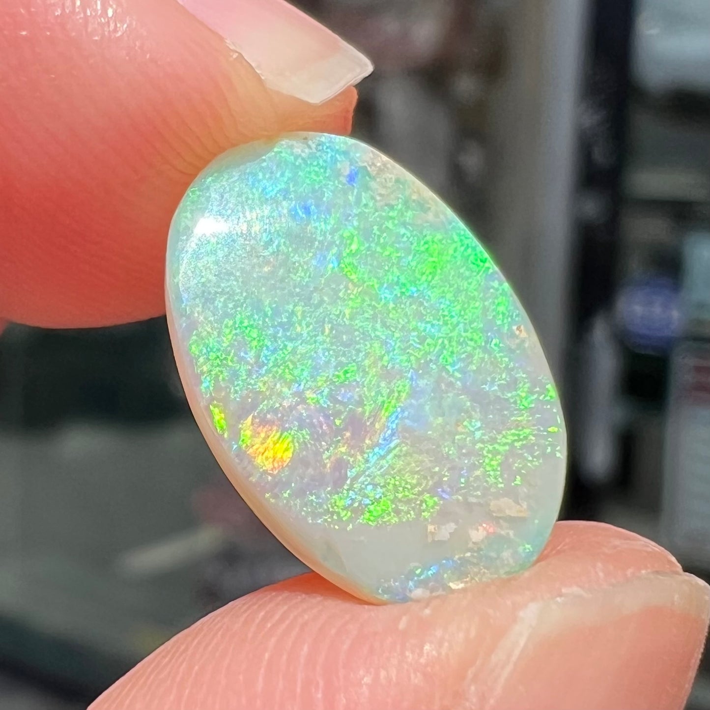 A double-sided opal stone from Coober Pedy, Australia. The opal plays green, blue, and orange colors from the front and the back.