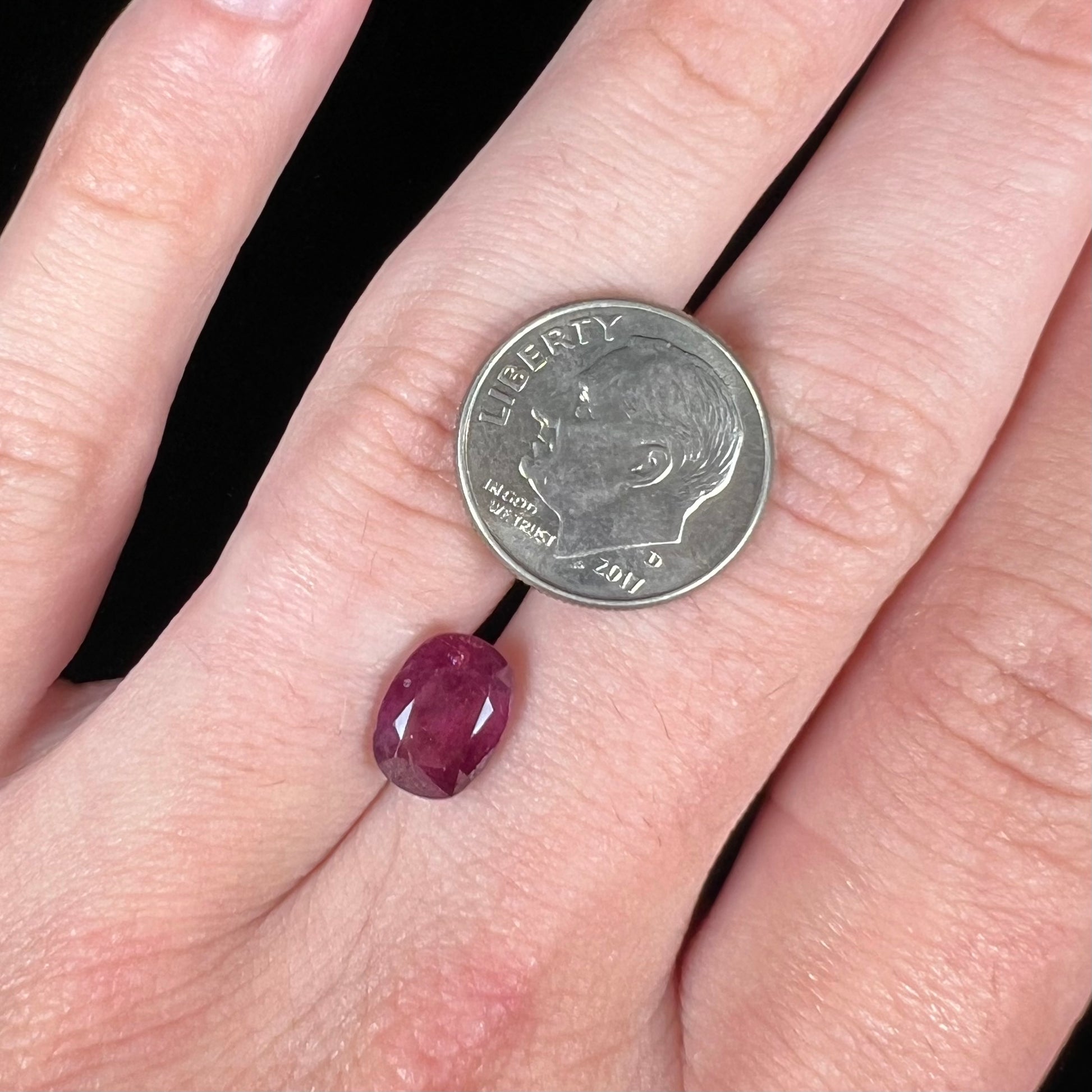 A loose, natural purplish ruby gemstone.  There is a small, minute chip on the girdle of the gem.