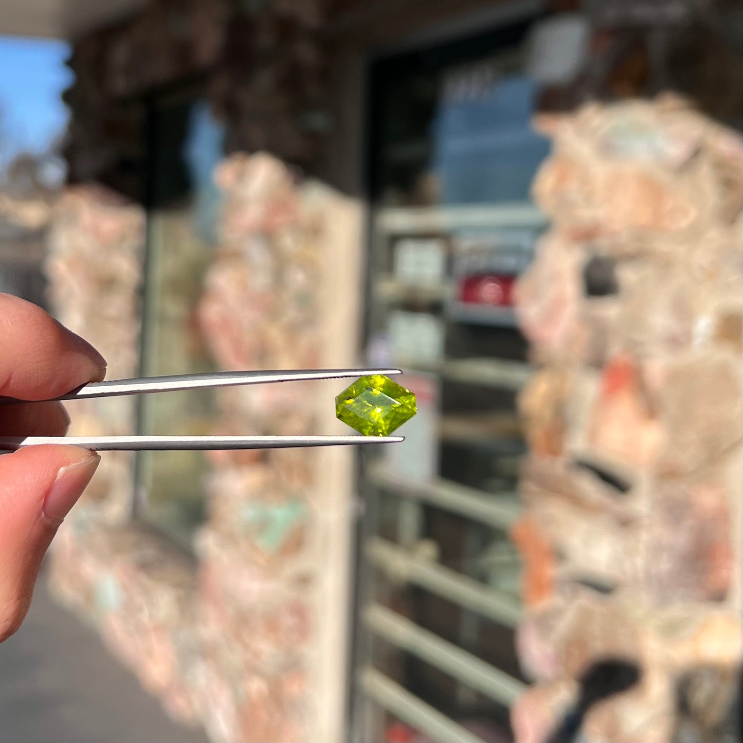 A loose, modified octagon peridot stone. The stone is a yellow green color.