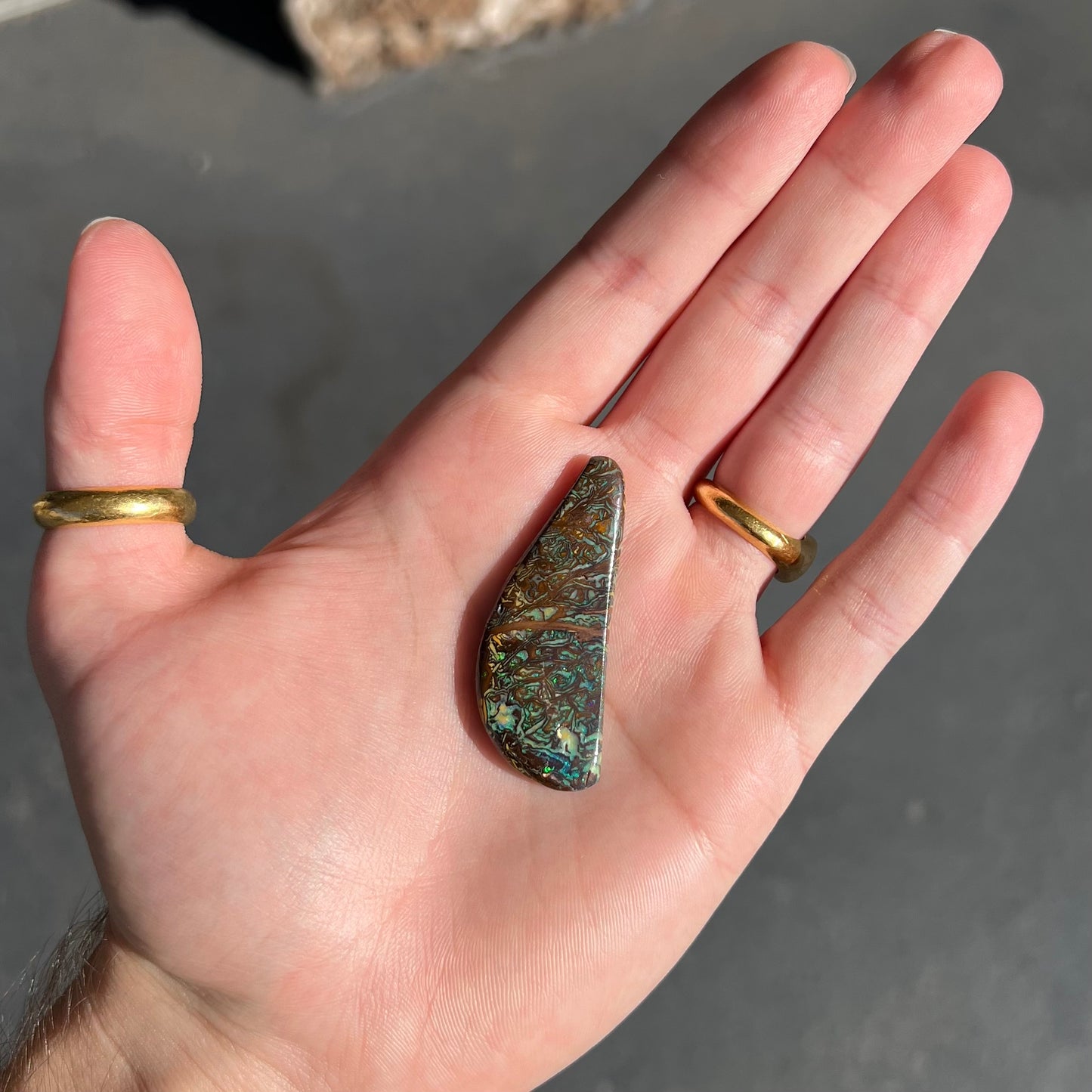 A loose, freeform boulder opal from Koroit, Australia. The opal has patterns.