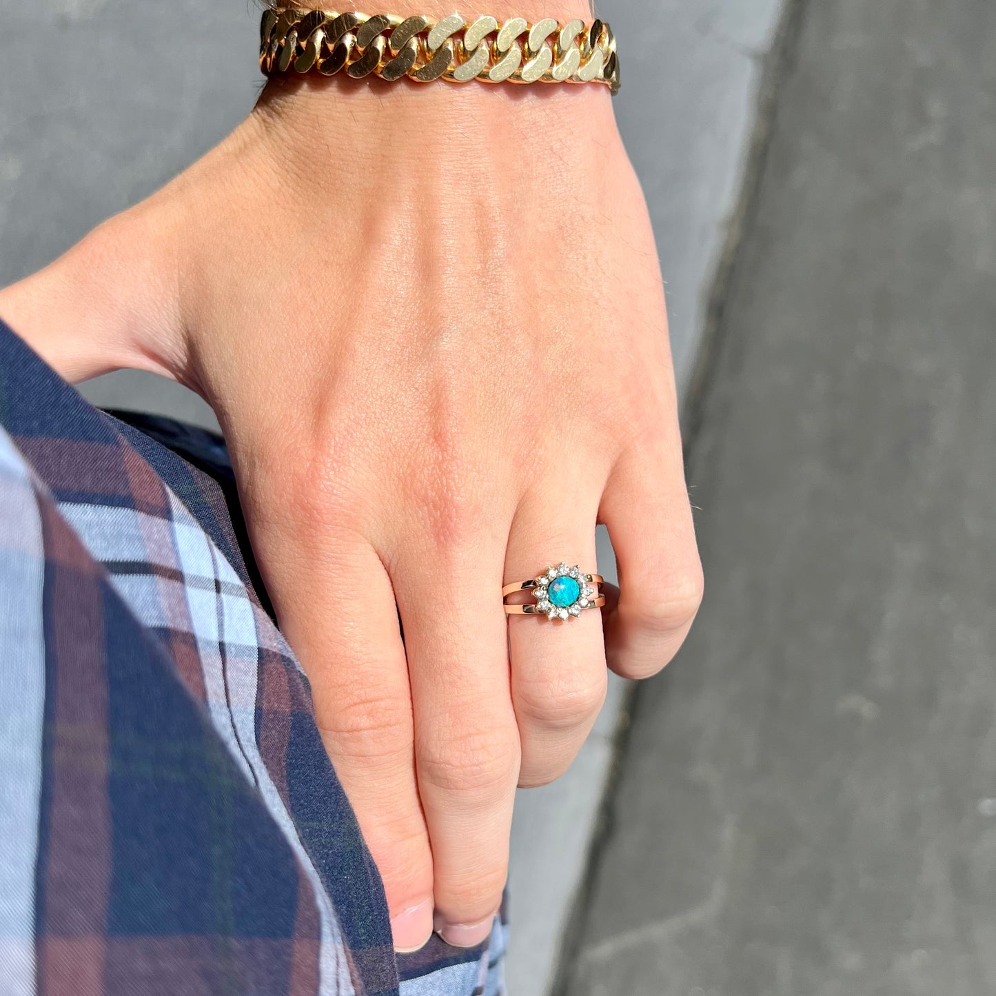 A ladies' round cut black opal and diamond halo ring. The ring is yellow gold and has a split shank.