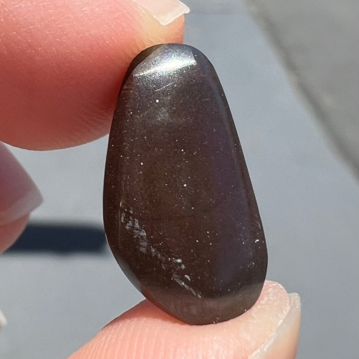 A loose boulder opal stone from Quilpie, Australia. The opal shines colors of green and orange.