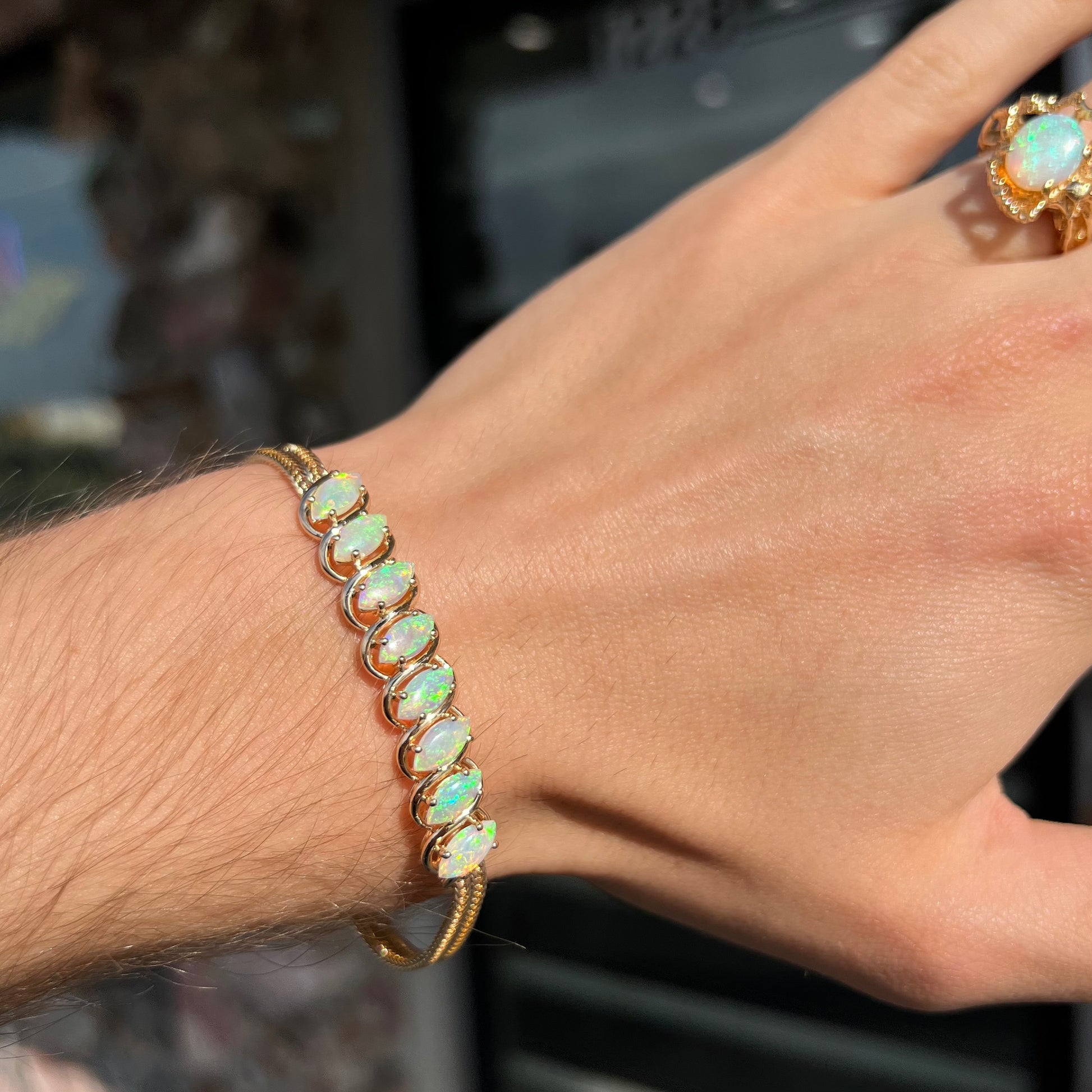 A ladies' yellow gold bracelet prong set with eight natural, marquise cabochon cut opals.