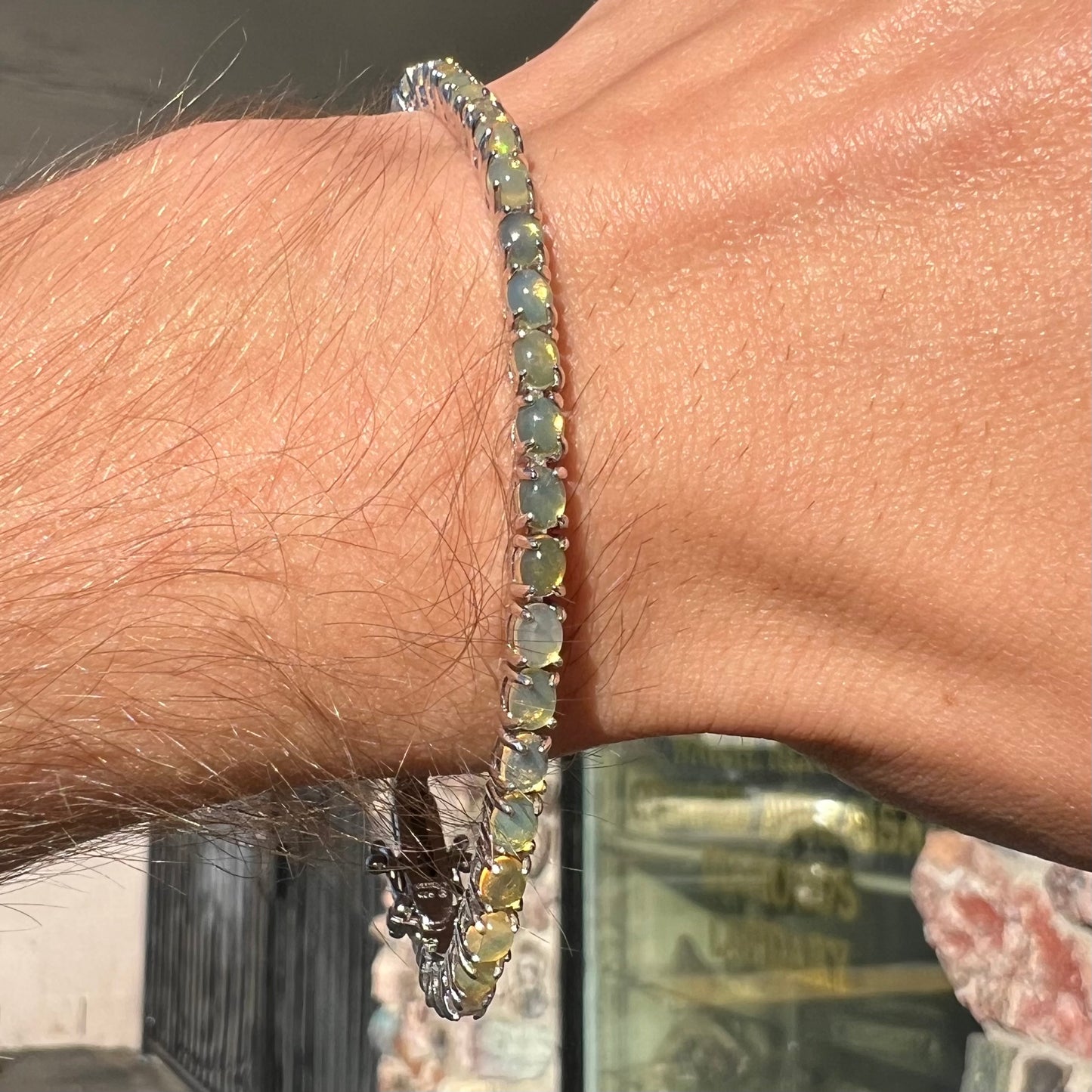 A ladies' sterling silver tennis style bracelet set with natural orange yellow Mexican fire opals.