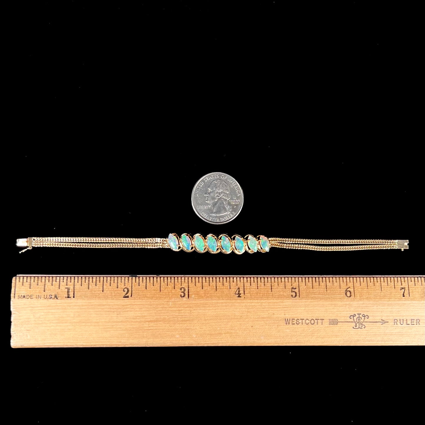 A ladies' yellow gold bracelet prong set with eight natural, marquise cabochon cut opals.