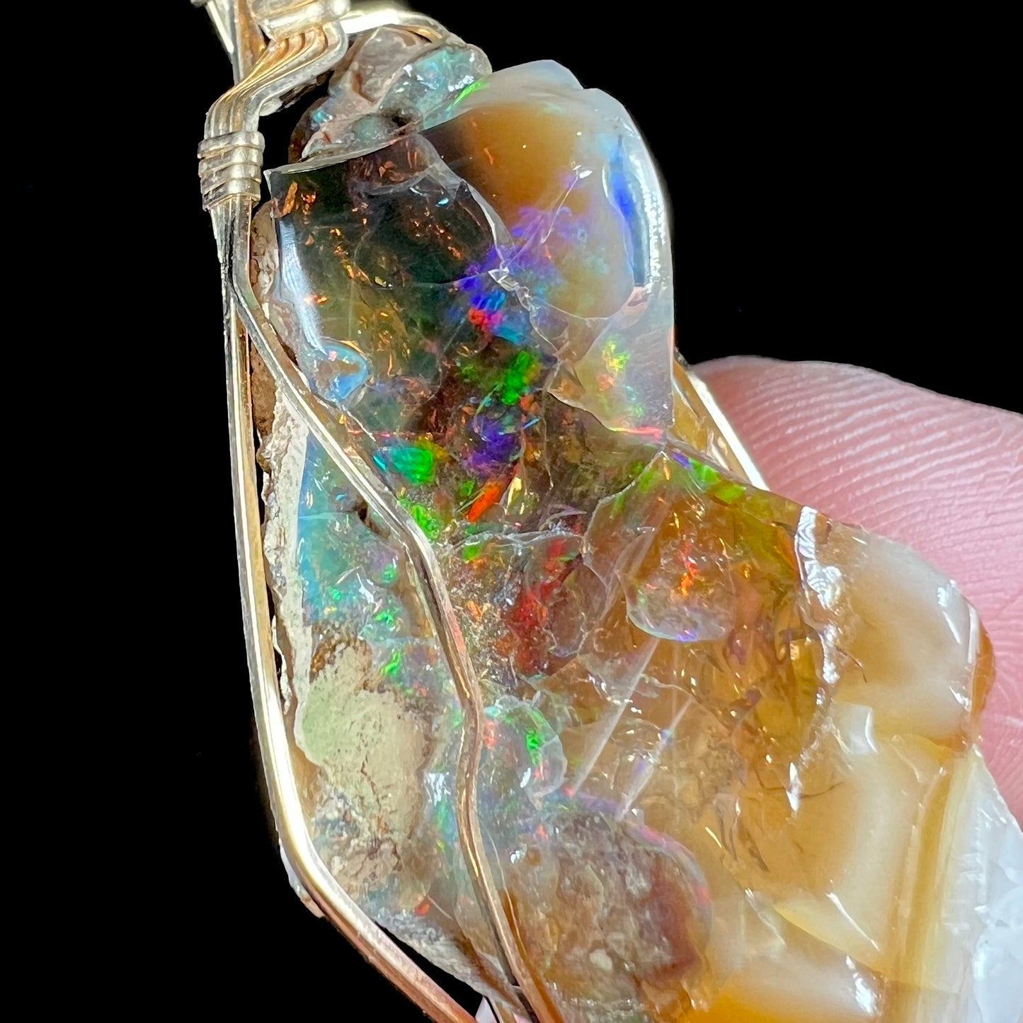A gold filled wire wrapped pendant set with a natural Virgin Valley, Nevada opal crystal.