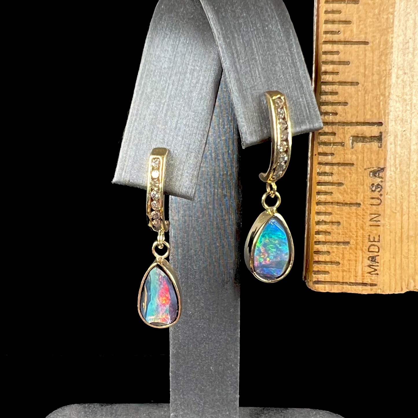 A pair of yellow gold dangle earrings set with natural pear shaped boulder opals and diamonds.