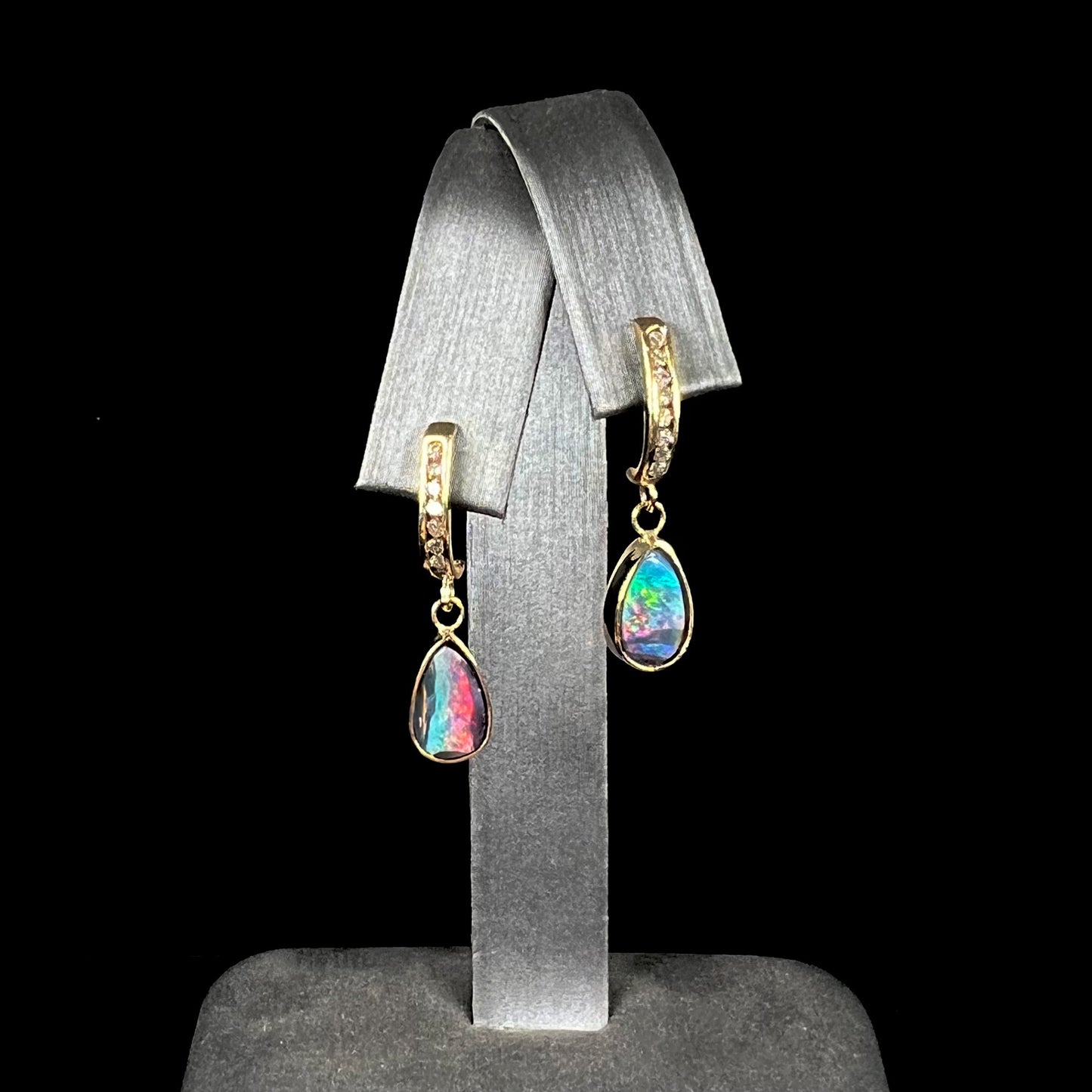 A pair of yellow gold dangle earrings set with natural pear shaped boulder opals and diamonds.
