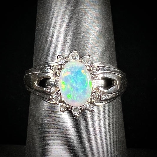 A ladies' white gold ring set with a halo of diamonds and an oval cabochon cut Australian opal.