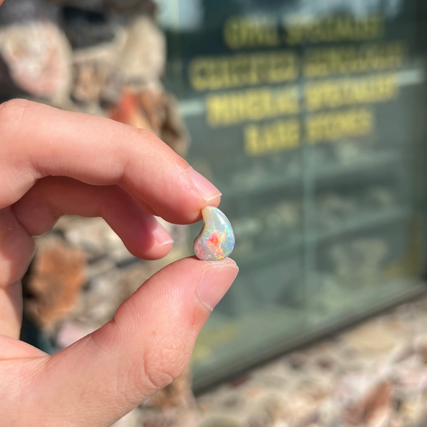 A loose, drop shaped opal stone from Lightning Ridge, Australia. The stone has bright red fire.