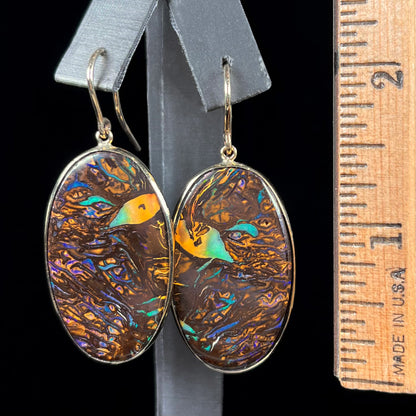 A pair of Koroit boulder opal dangle earrings set in yellow gold bezels.