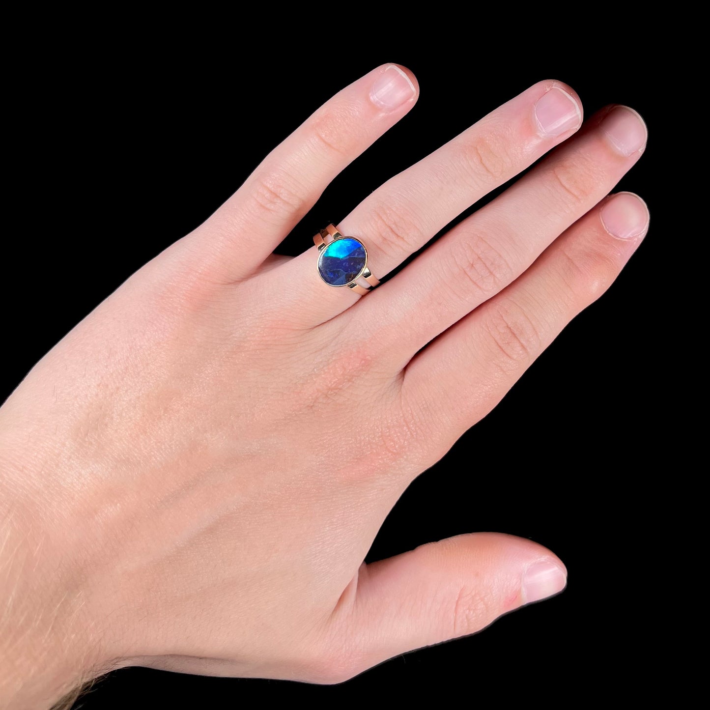 A ladies' split shank natural, Lightning Ridge, Australian black opal solitaire ring in yellow gold.