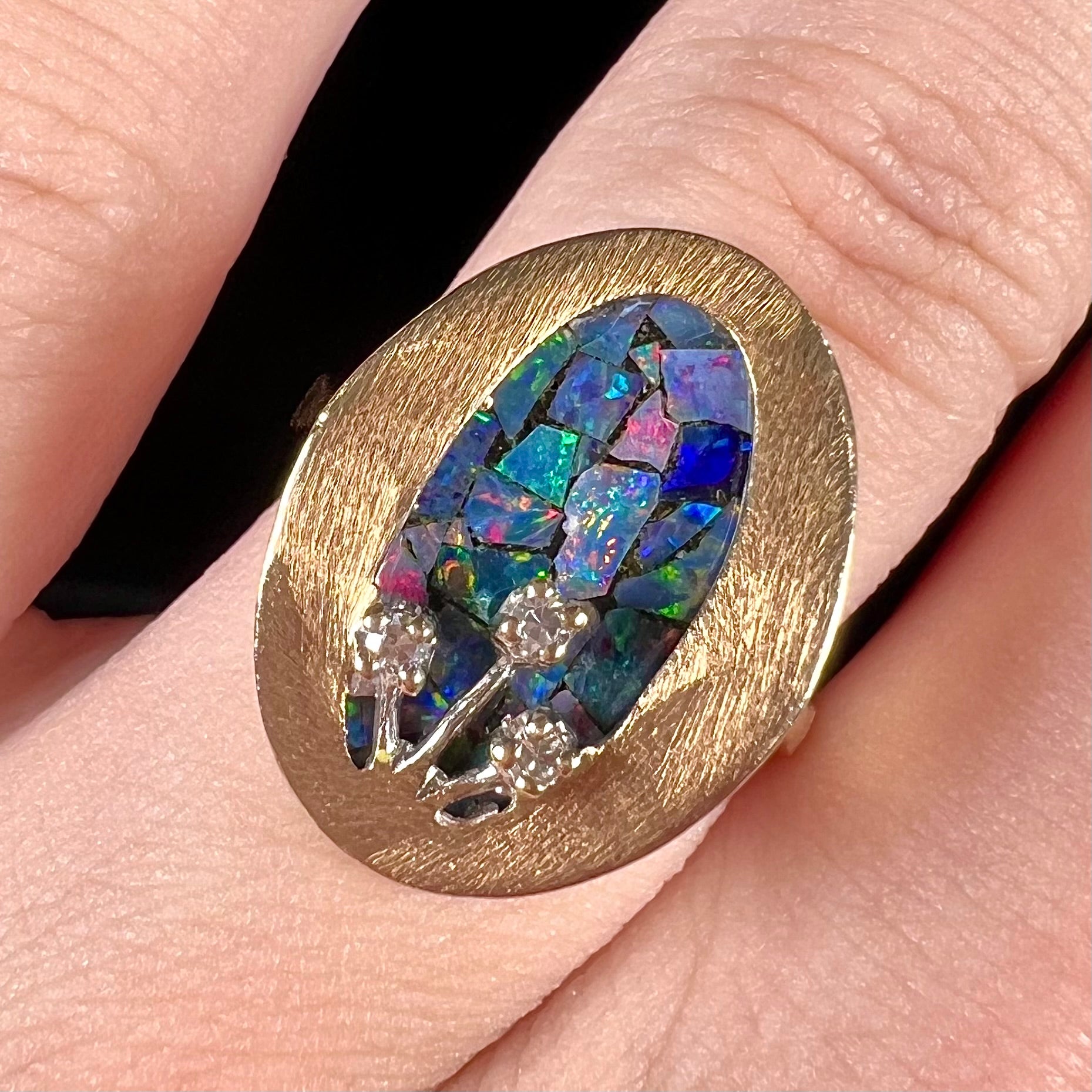 A vintage mosaic opal ring set with diamond accents in 10 karat yellow and white gold.