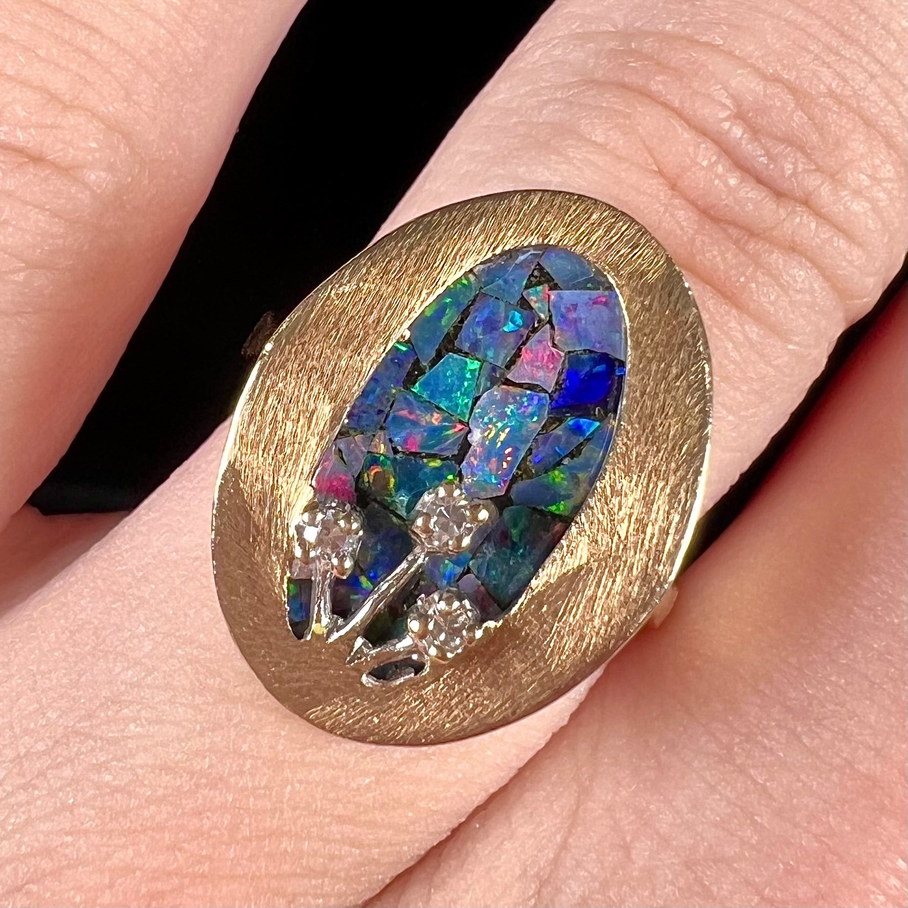 A vintage mosaic opal ring set with diamond accents in 10 karat yellow and white gold.