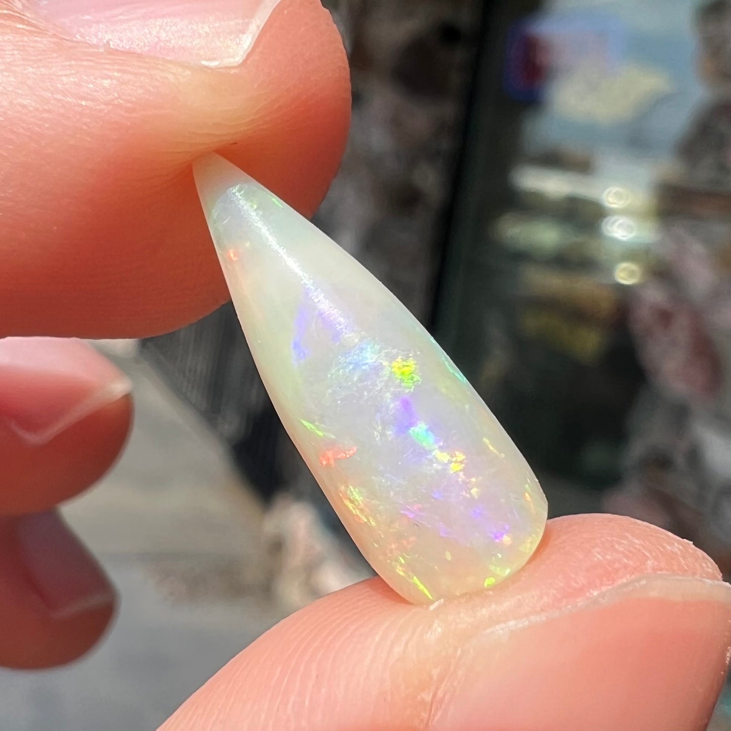An opalized belemnite fossil from Coober Pedy, Australia. The specimen has red, yellow, and green play of color.