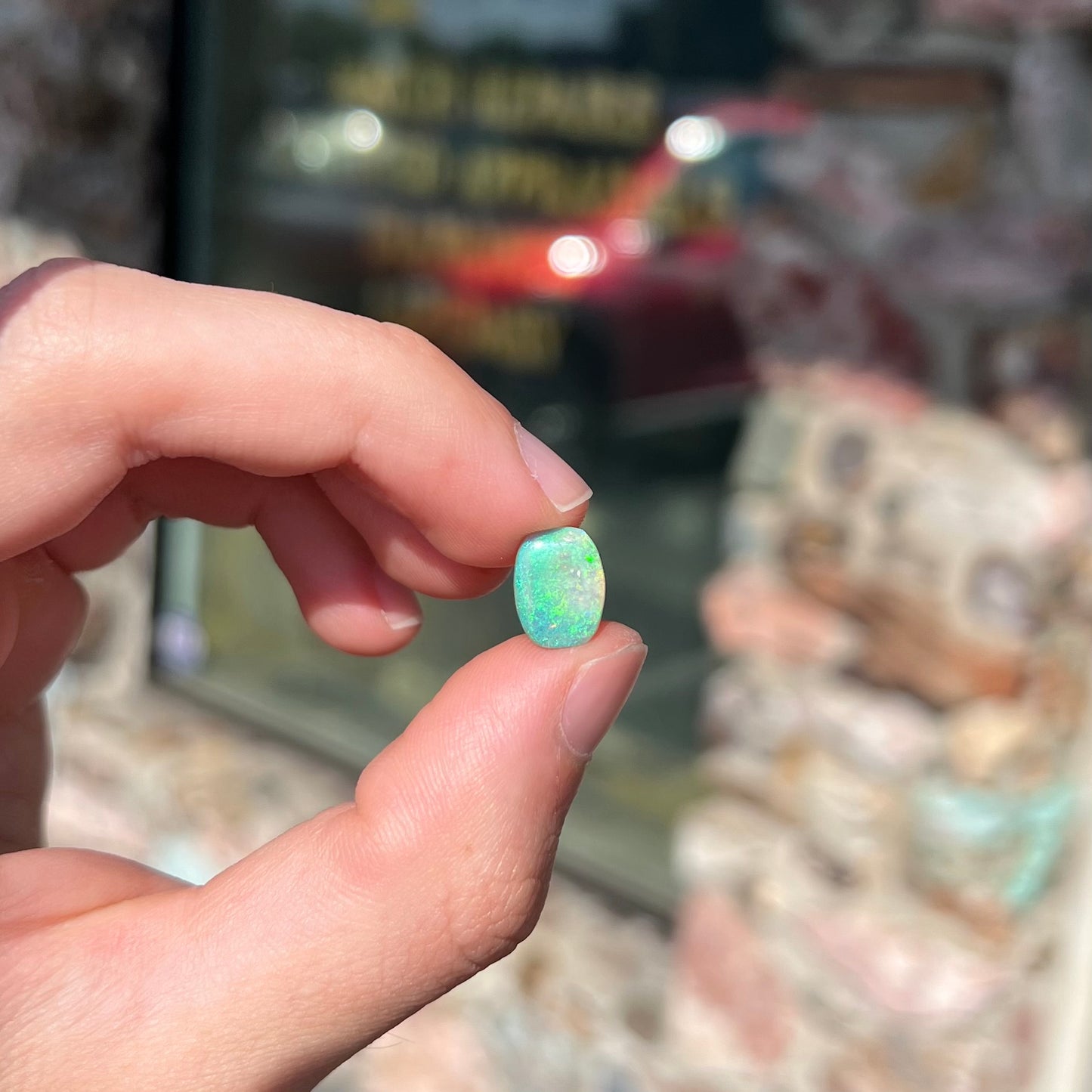 A 2.40ct barrel shaped Lightning Ridge semi-crystal opal. The stone has blue and green colors.