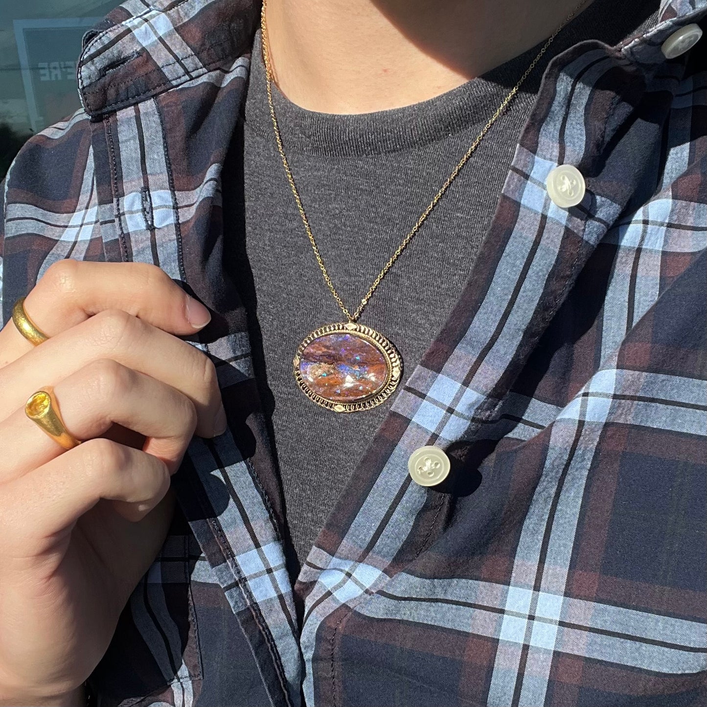 A yellow gold filigree style brooch/pendant combination piece set with a purple opalized wood stone from Duck Creek, Australia.