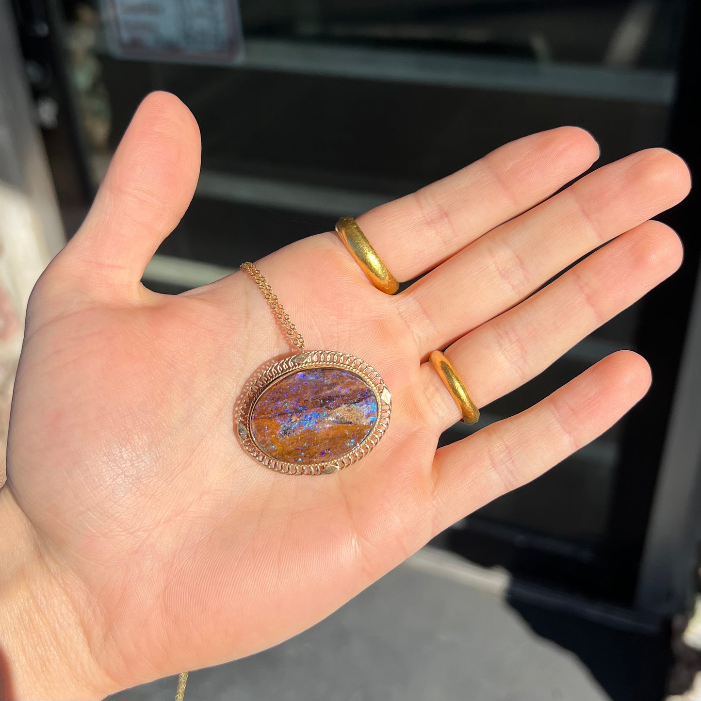 A yellow gold filigree style brooch/pendant combination piece set with a purple opalized wood stone from Duck Creek, Australia.