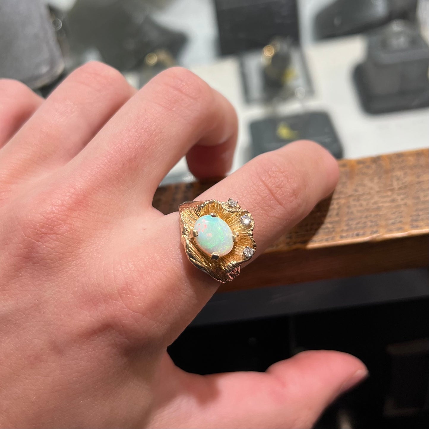 A 1960s style white opal and diamond ring. The ring has an organic, ruffled gold design.