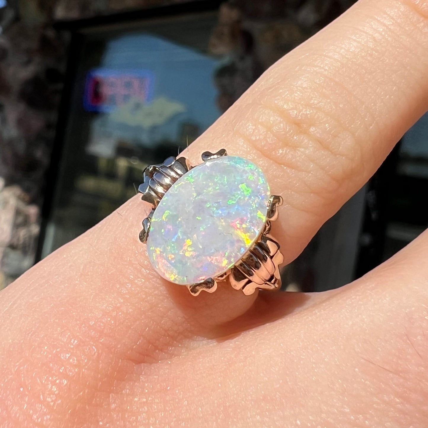 A ladies' Art Deco style natural opal solitaire ring in yellow gold. The opal is oval cut.