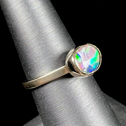 A yellow gold solitaire ring set with a natural Australian cat's eye opal stone.