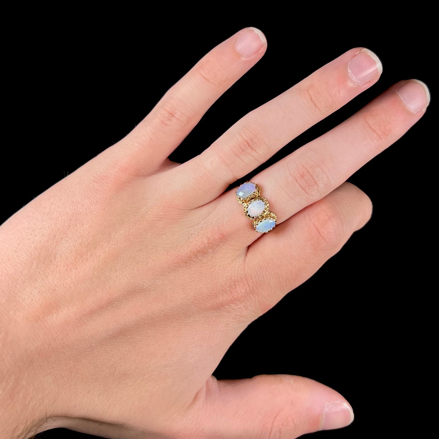 A vintage ladies' three stone gold ring set with natural white crystal opals.