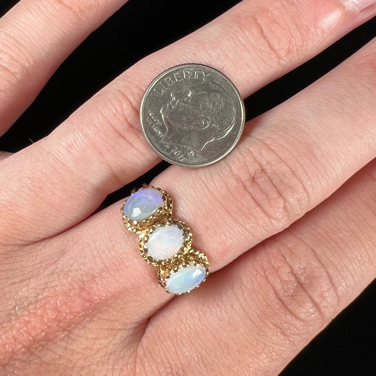A vintage ladies' three stone gold ring set with natural white crystal opals.