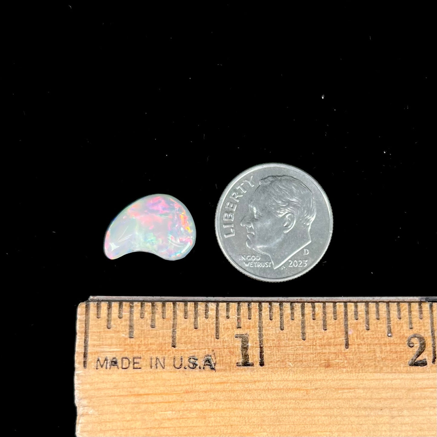 A loose, drop shaped opal stone from Lightning Ridge, Australia. The stone has bright red fire.