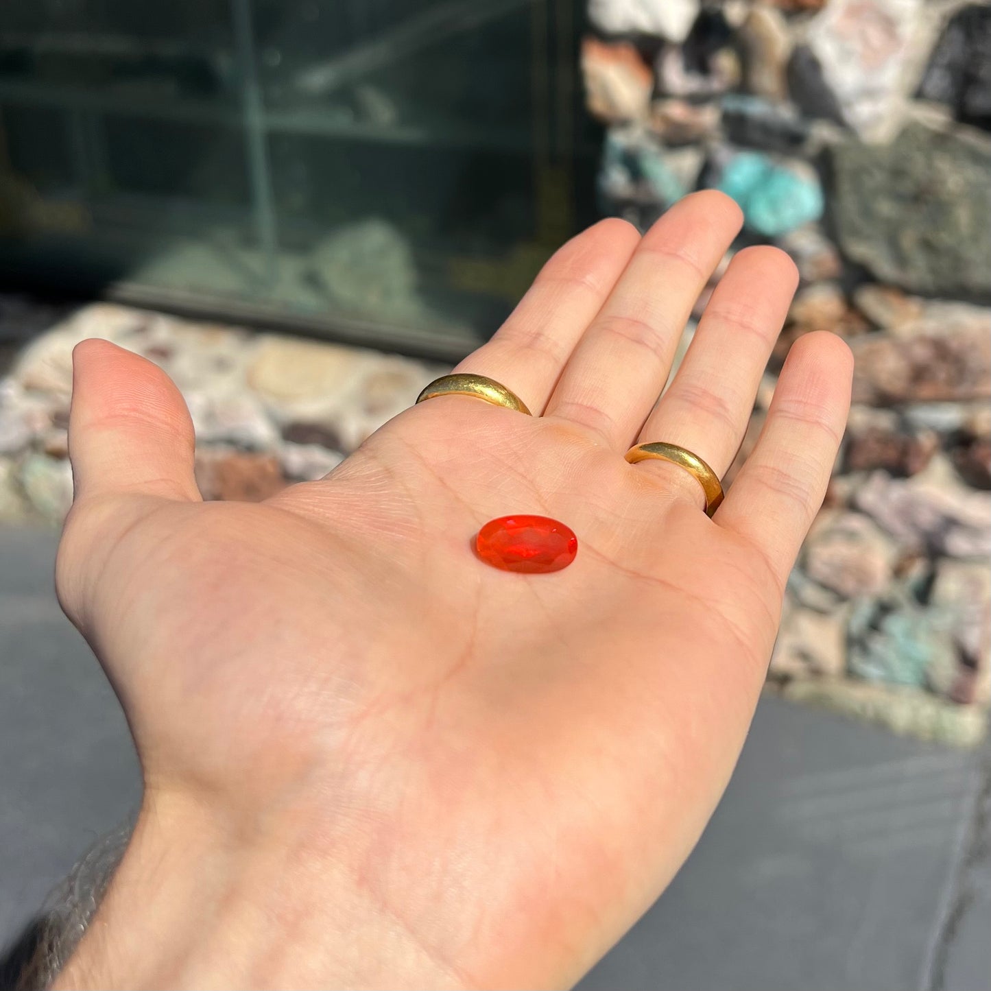 A loose, faceted oval cut Mexican fire opal stone. The stone is a bright orange color.