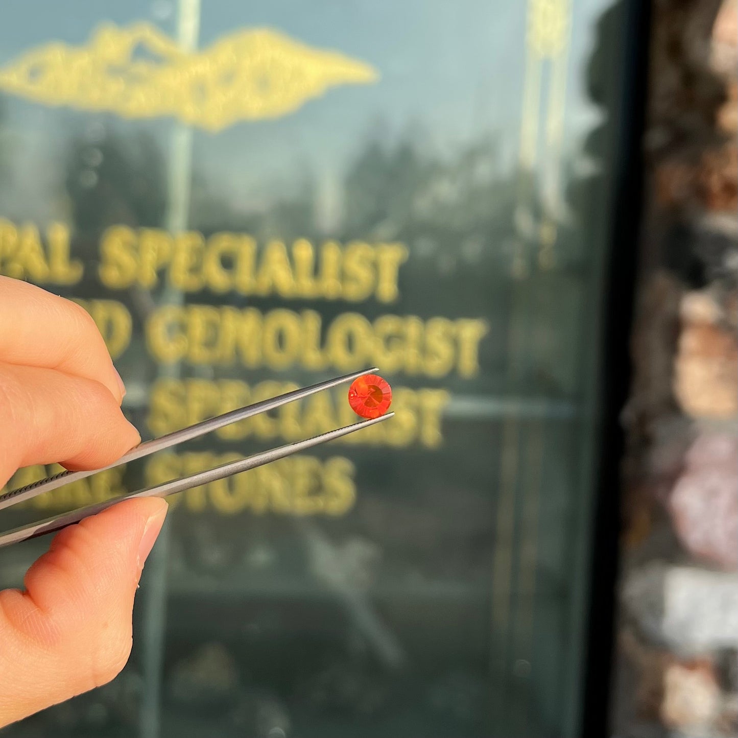 A faceted round cut natural fire opal from Mexico. The stone is a bright orange color.