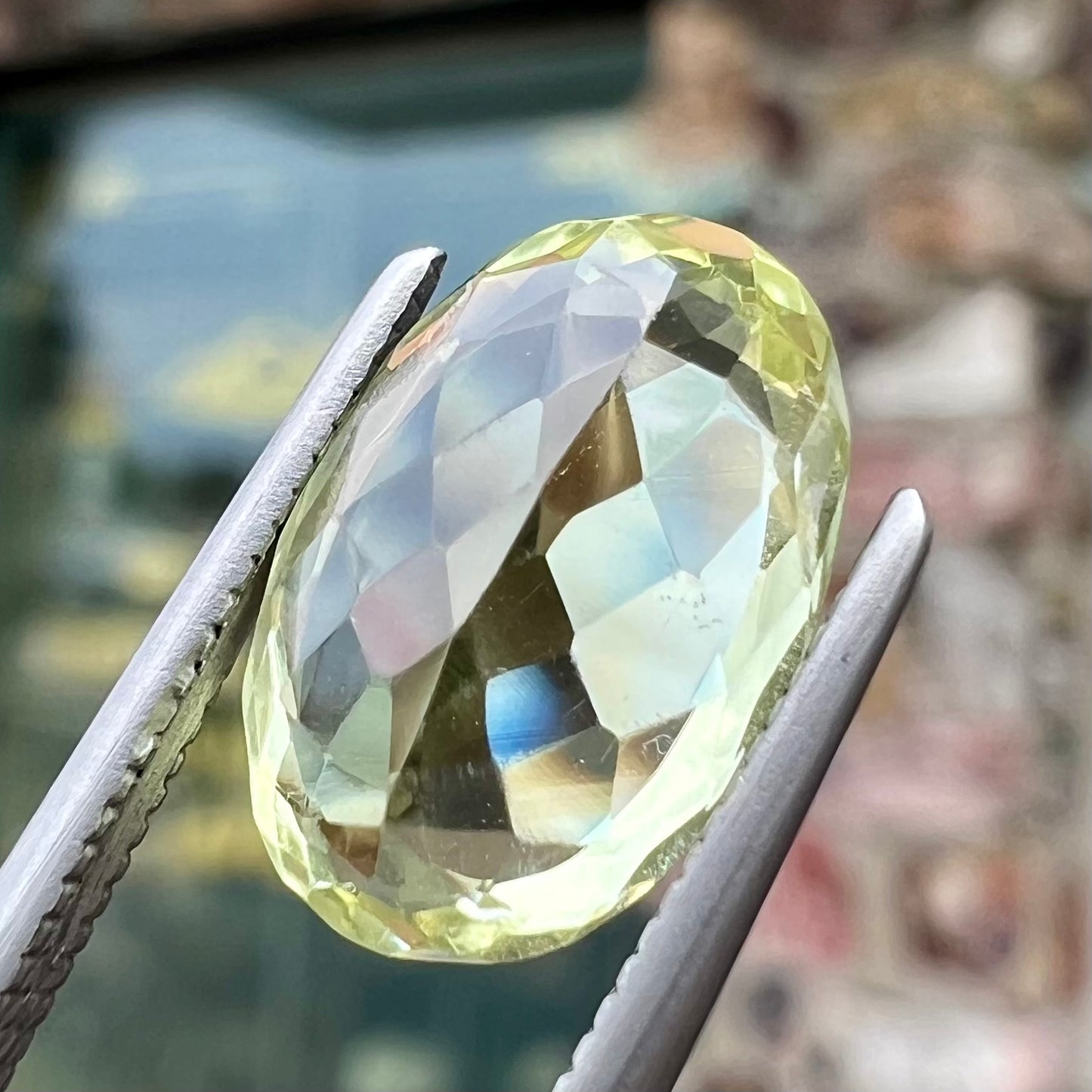 A loose, faceted oval cut chrysoberyl gemstone. The stone is a greenish yellow color.