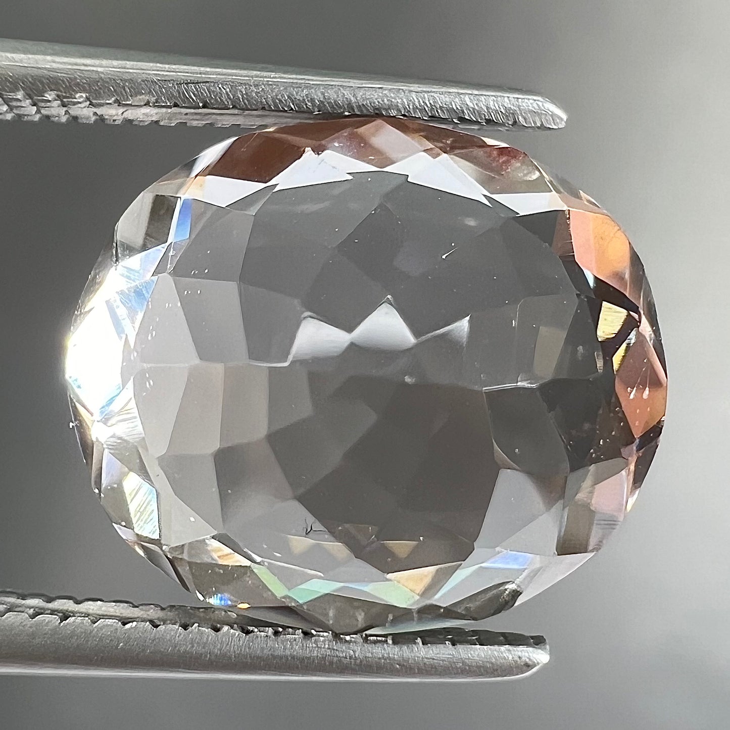 A loose, faceted oval cut pink morganite gemstone.