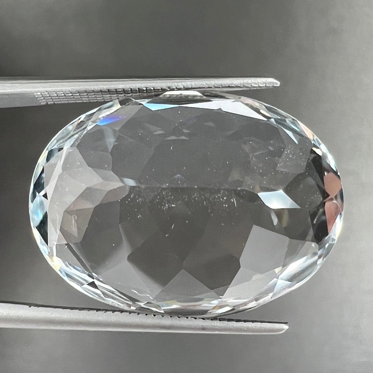 A loose, faceted oval cut white topaz gemstone. The stone is large in size.