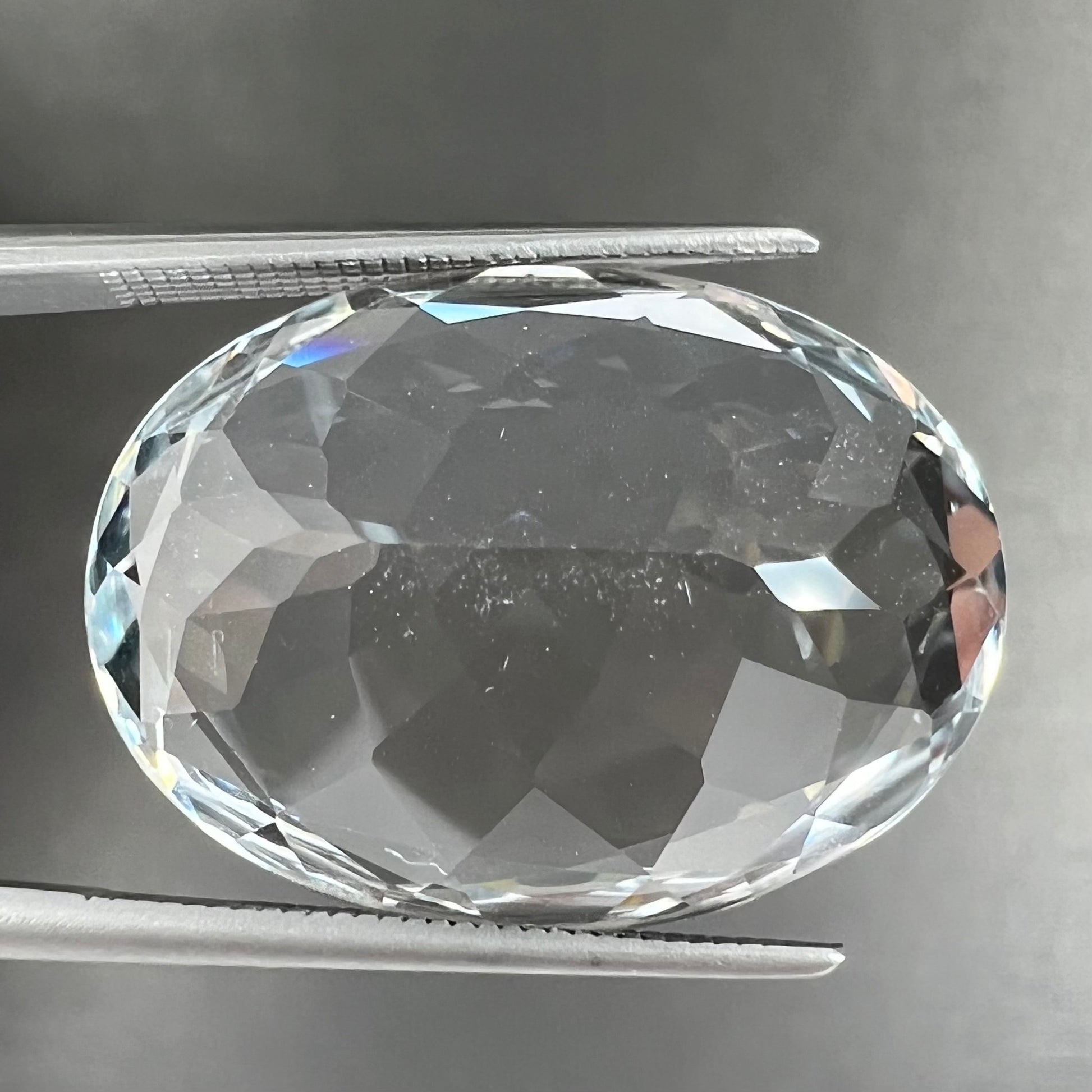 A loose, faceted oval cut white topaz gemstone.  The stone is large in size.