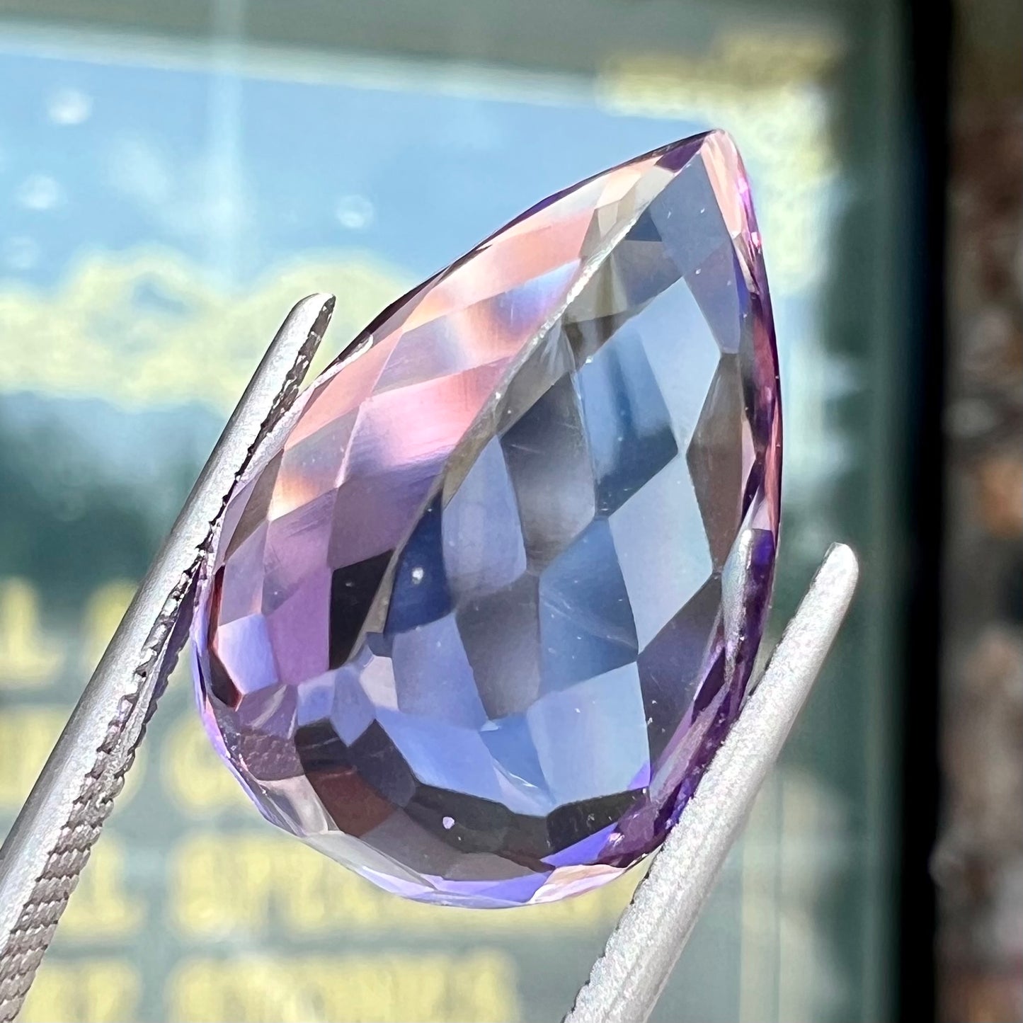 A loose, pear shaped amethyst gemstone. The stone is a medium purple color.