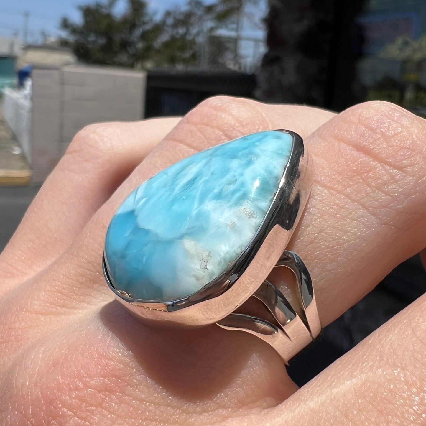 A ladies' large, pear shaped larimar solitaire ring in sterling silver. The larimar stone measures an inch long.