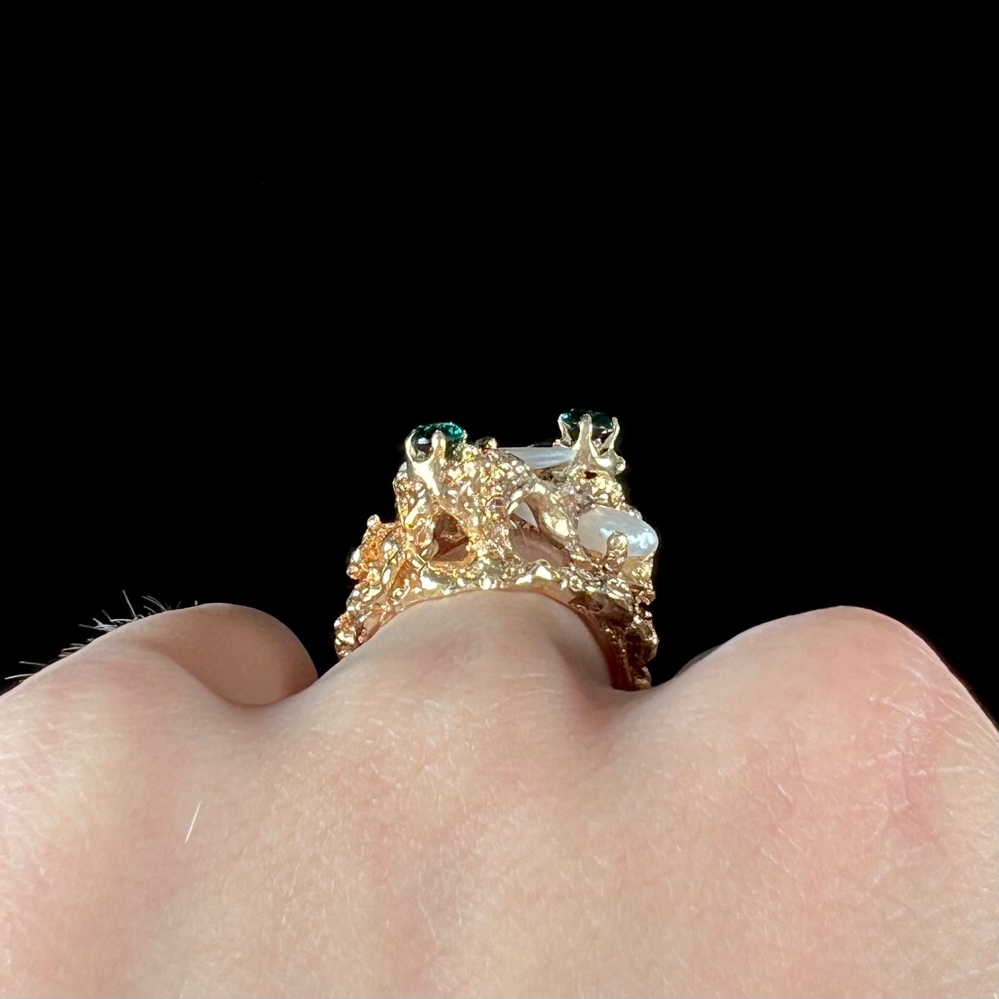 A vintage 1950's gold cluster ring set with freshwater pearls and green imitation emeralds.