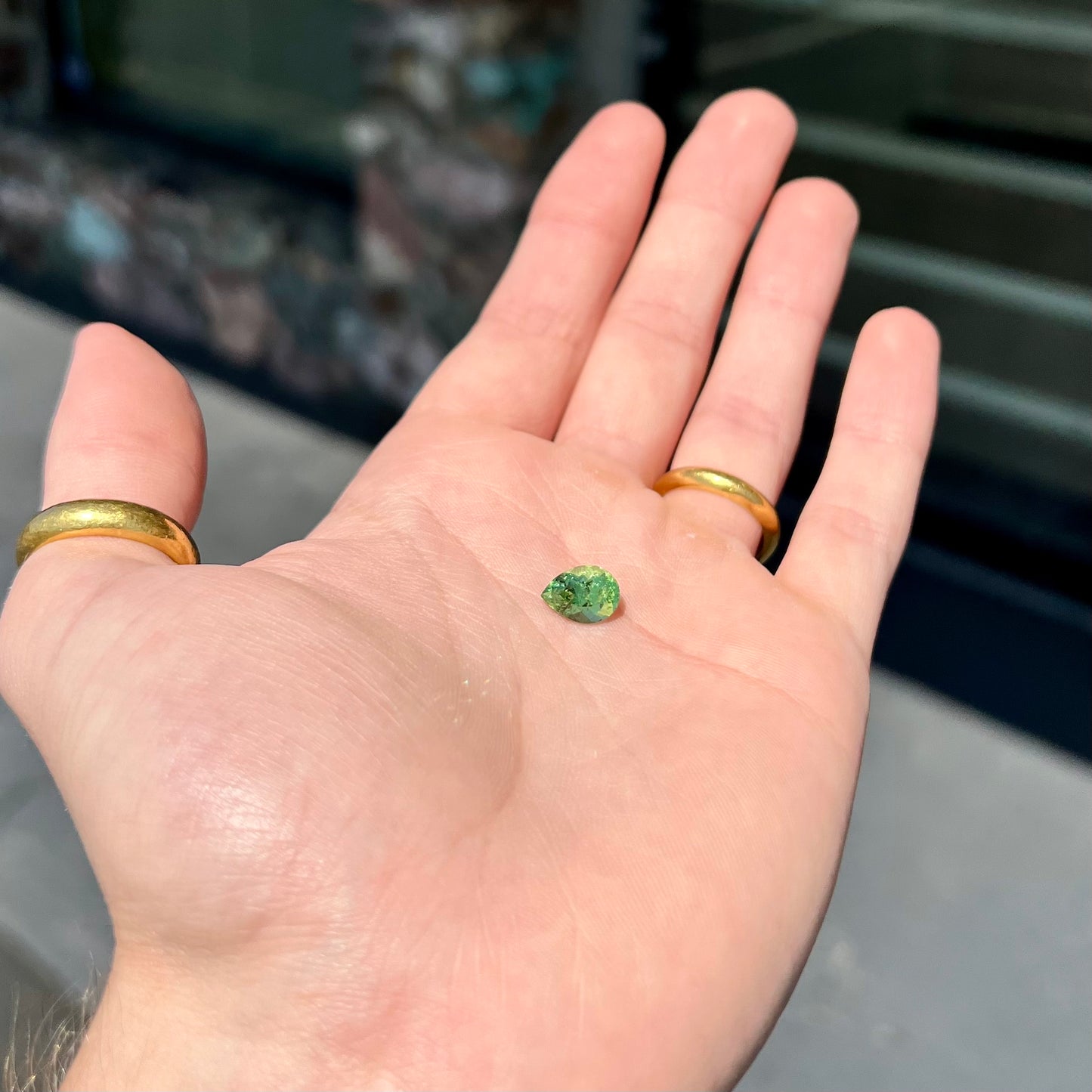 A loose, pear shaped tsavorite garnet gemstone. The stone is yellowish green.