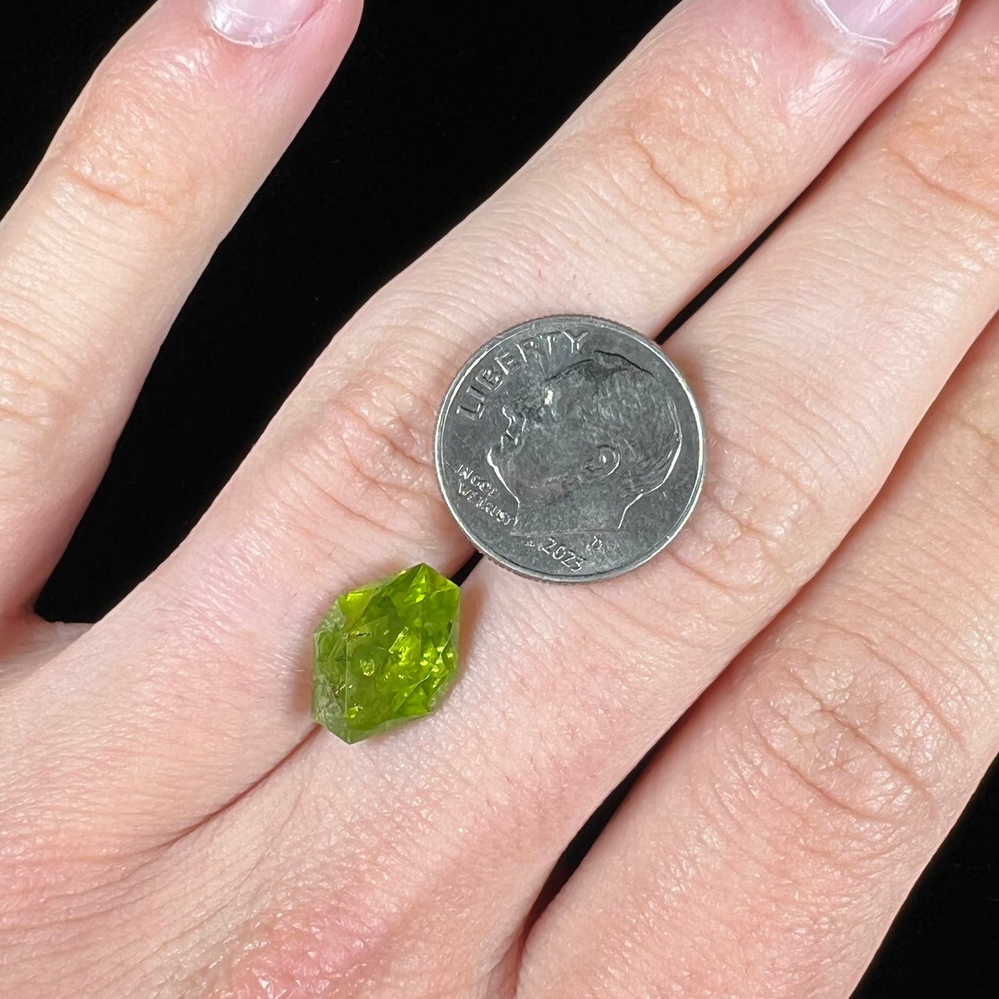 A loose, modified octagon peridot stone. The stone is a yellow green color.